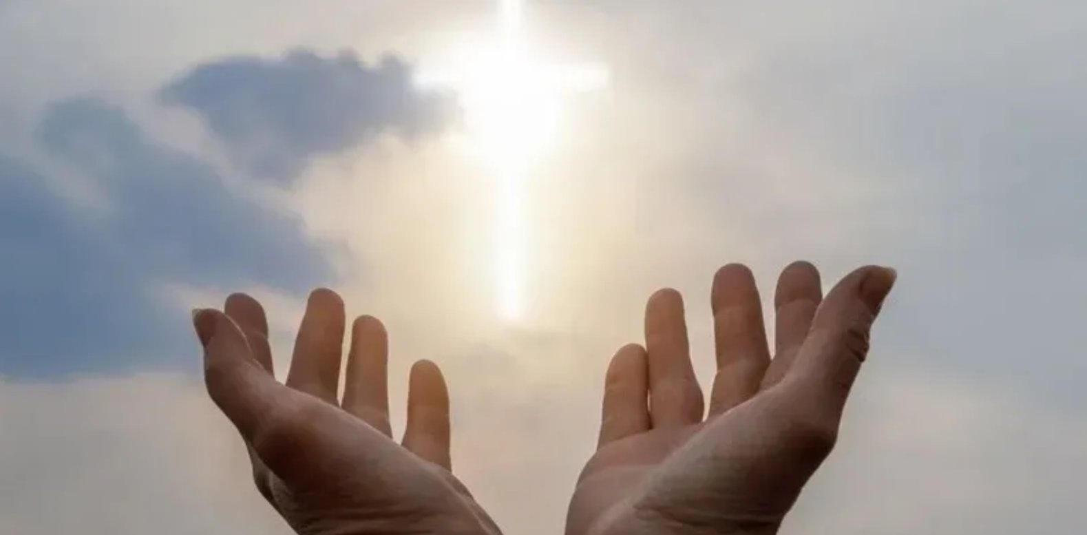 Hands raised toward a cross-shaped light in the sky